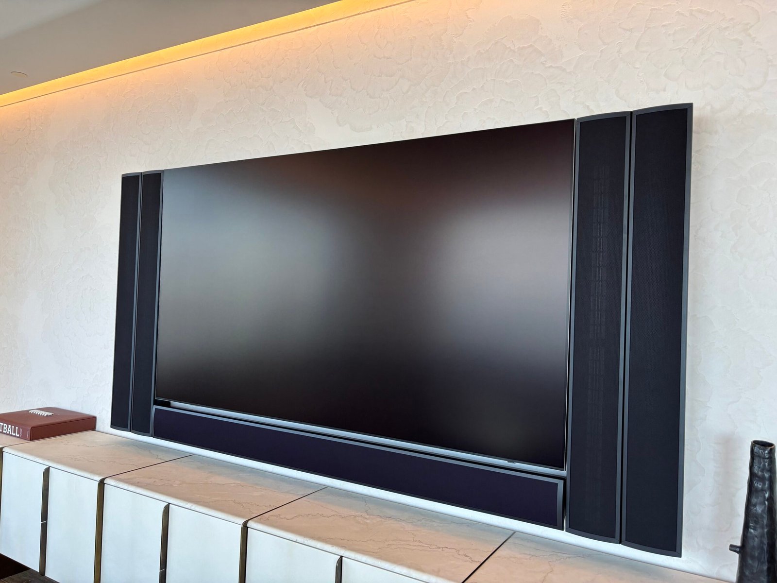 TV mounted in a black upholstered wall panel with LED lighting, NYC