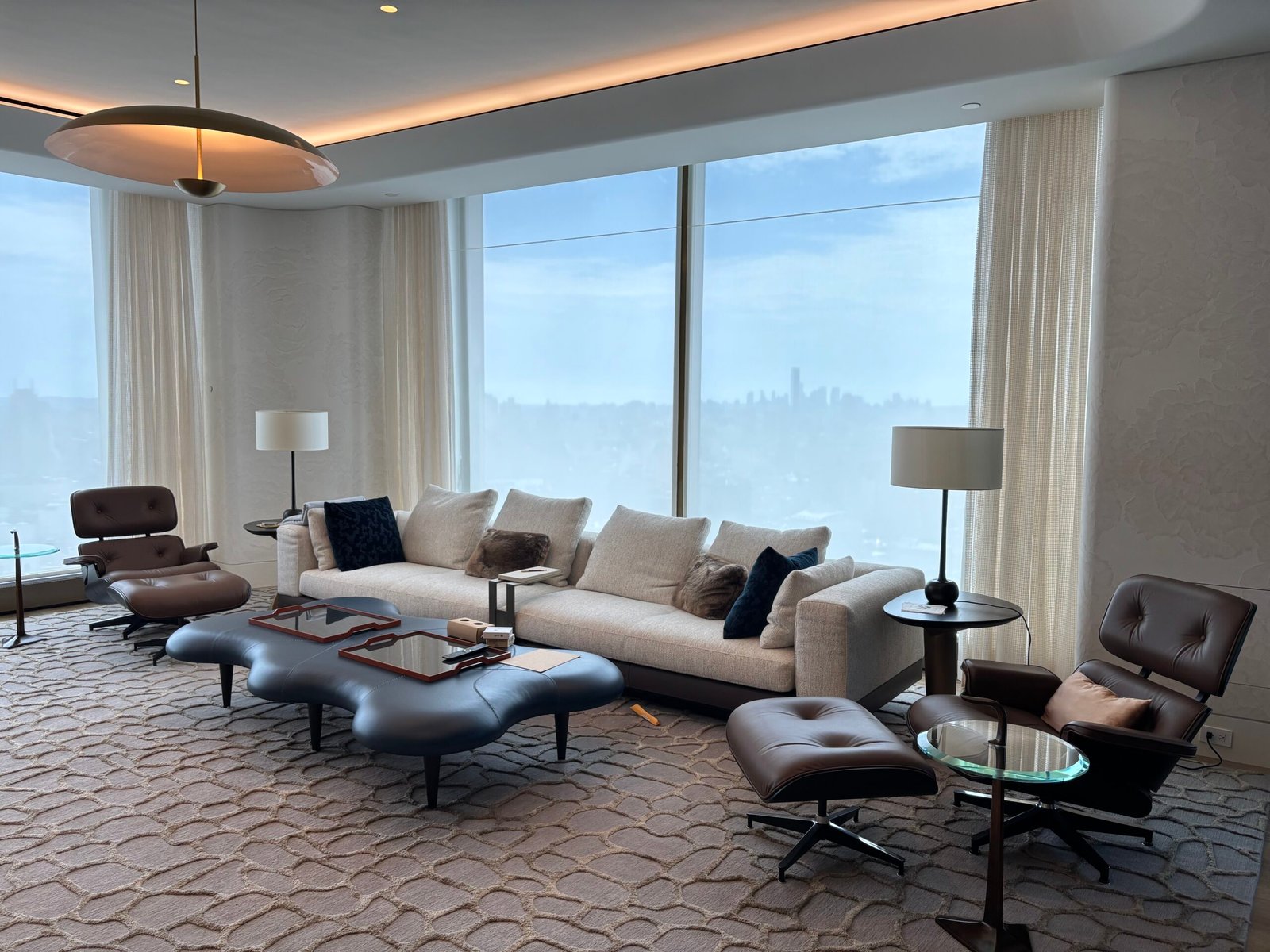 High-rise living room with sofa and lounge chairs after installation, NYC