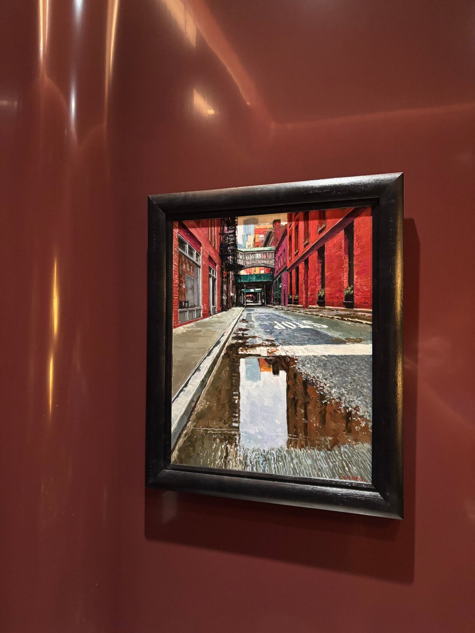Framed street photograph hung on a red wall, NYC