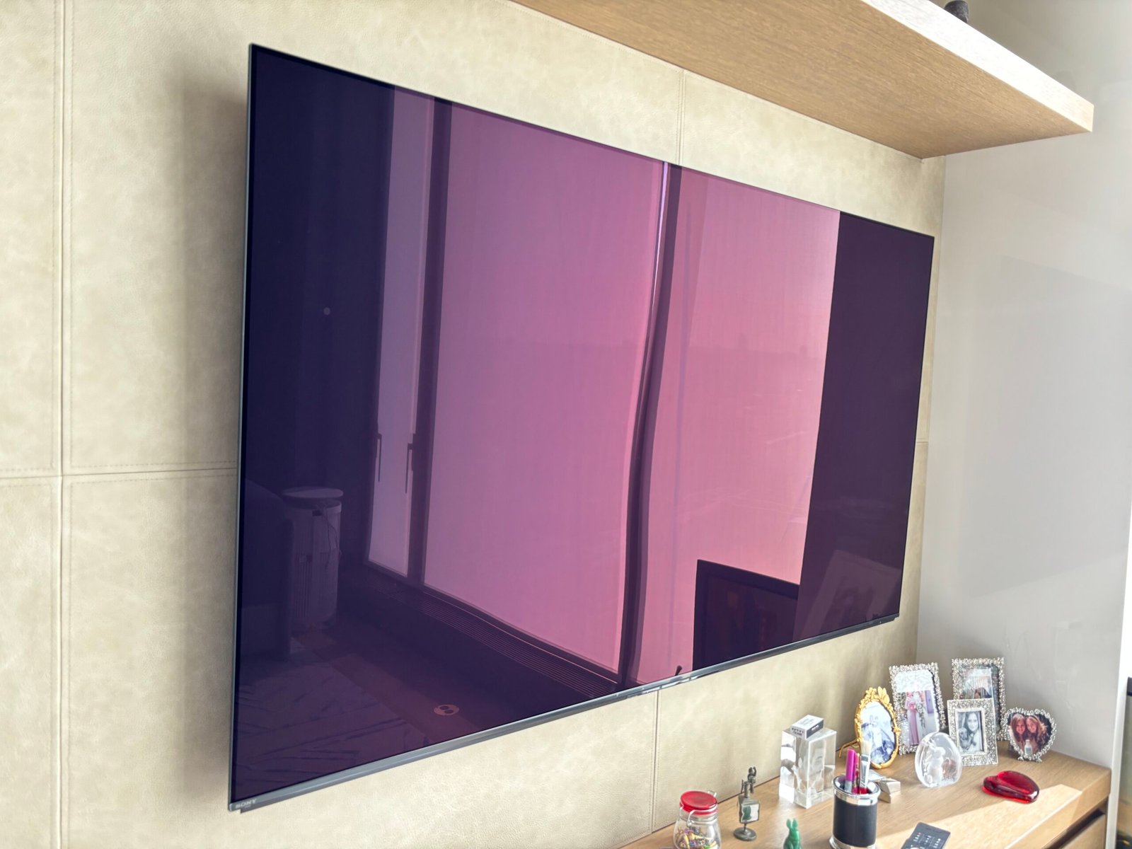 TV wall mounted above a floating shelf, NYC apartment