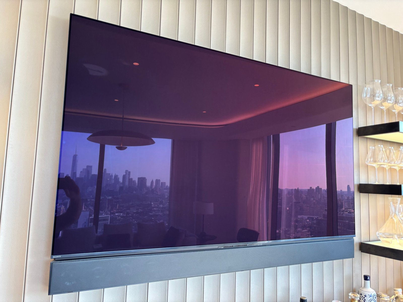 TV and soundbar mounted on a fluted wall with skyline view, NYC