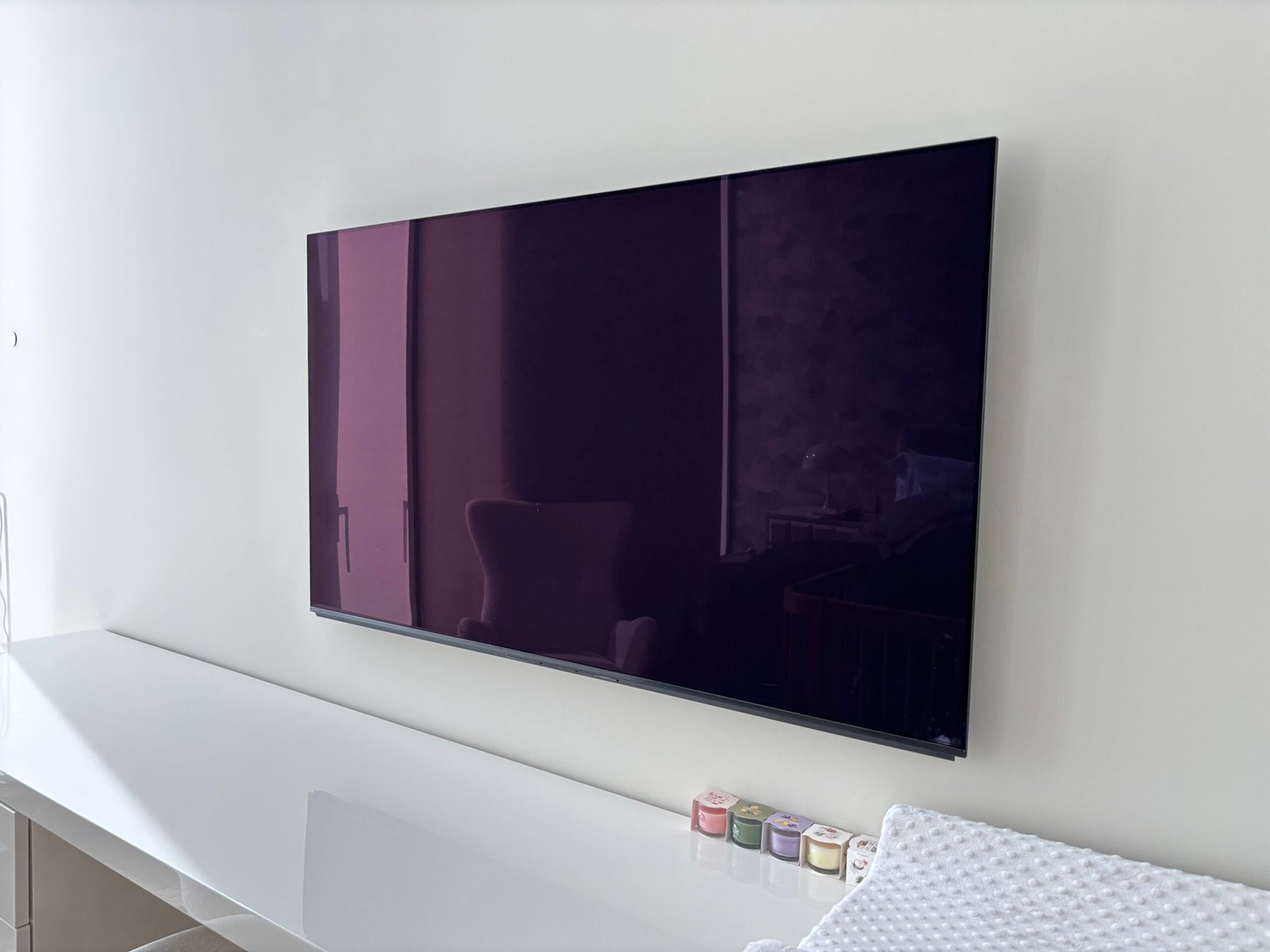 TV wall mounted above a white media console, NYC