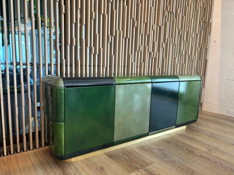 Green lacquer sideboard installed against a wood slat wall, NYC