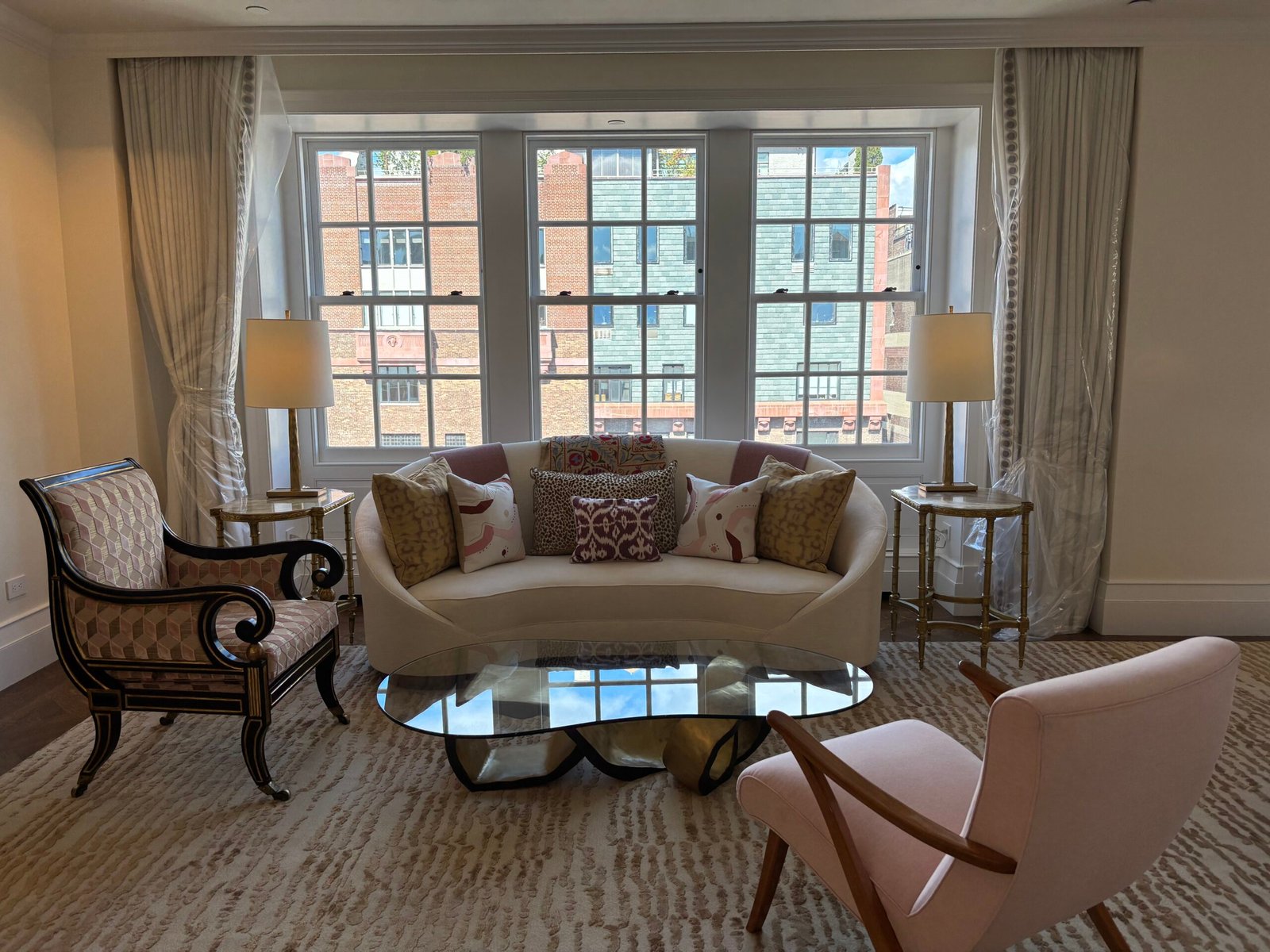 Living room with curved sofa and glass coffee table after installation, NYC