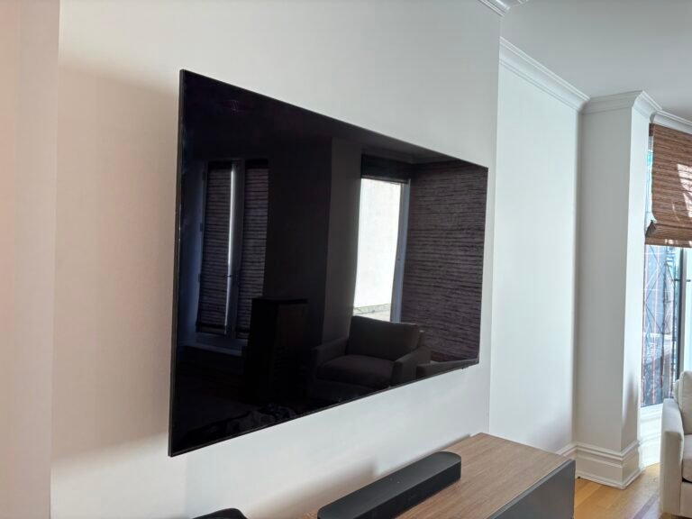 TV mounted on a wall with soundbar on a console, NYC apartment