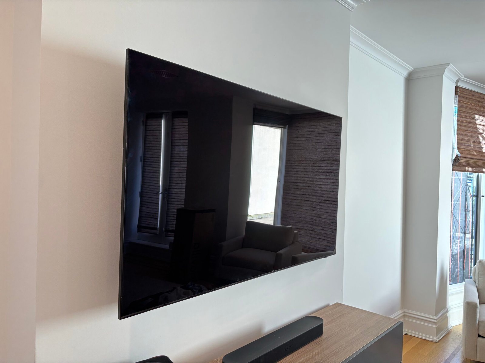 TV mounted on a wall with soundbar on a console, NYC apartment