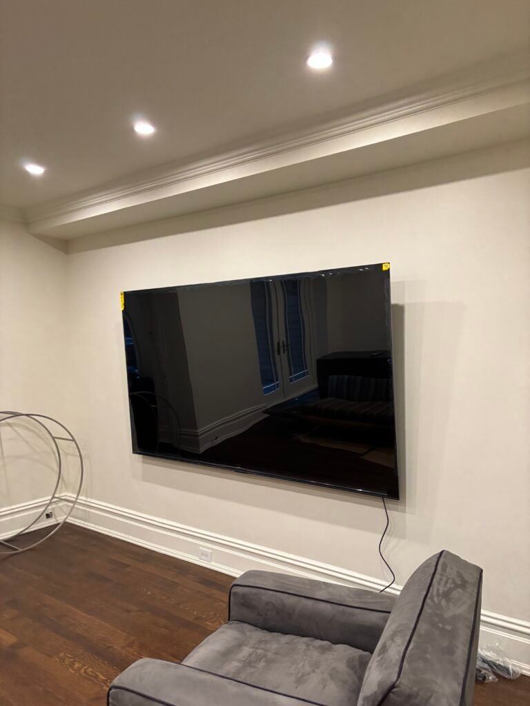 TV mounted on a wall in a room with crown molding, NYC