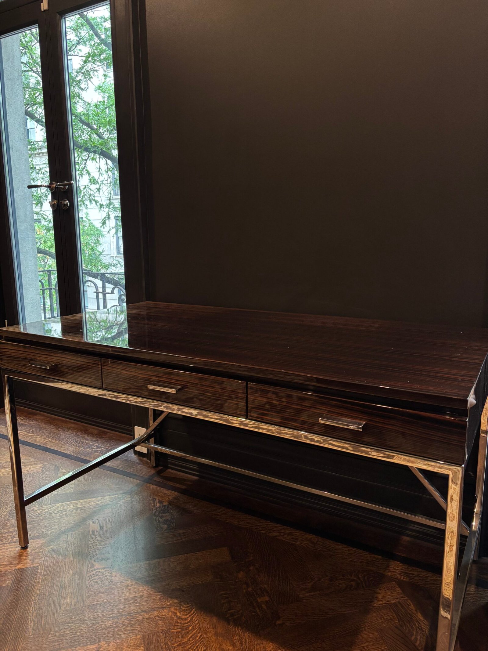Wood desk with metal legs placed in a dark room, NYC