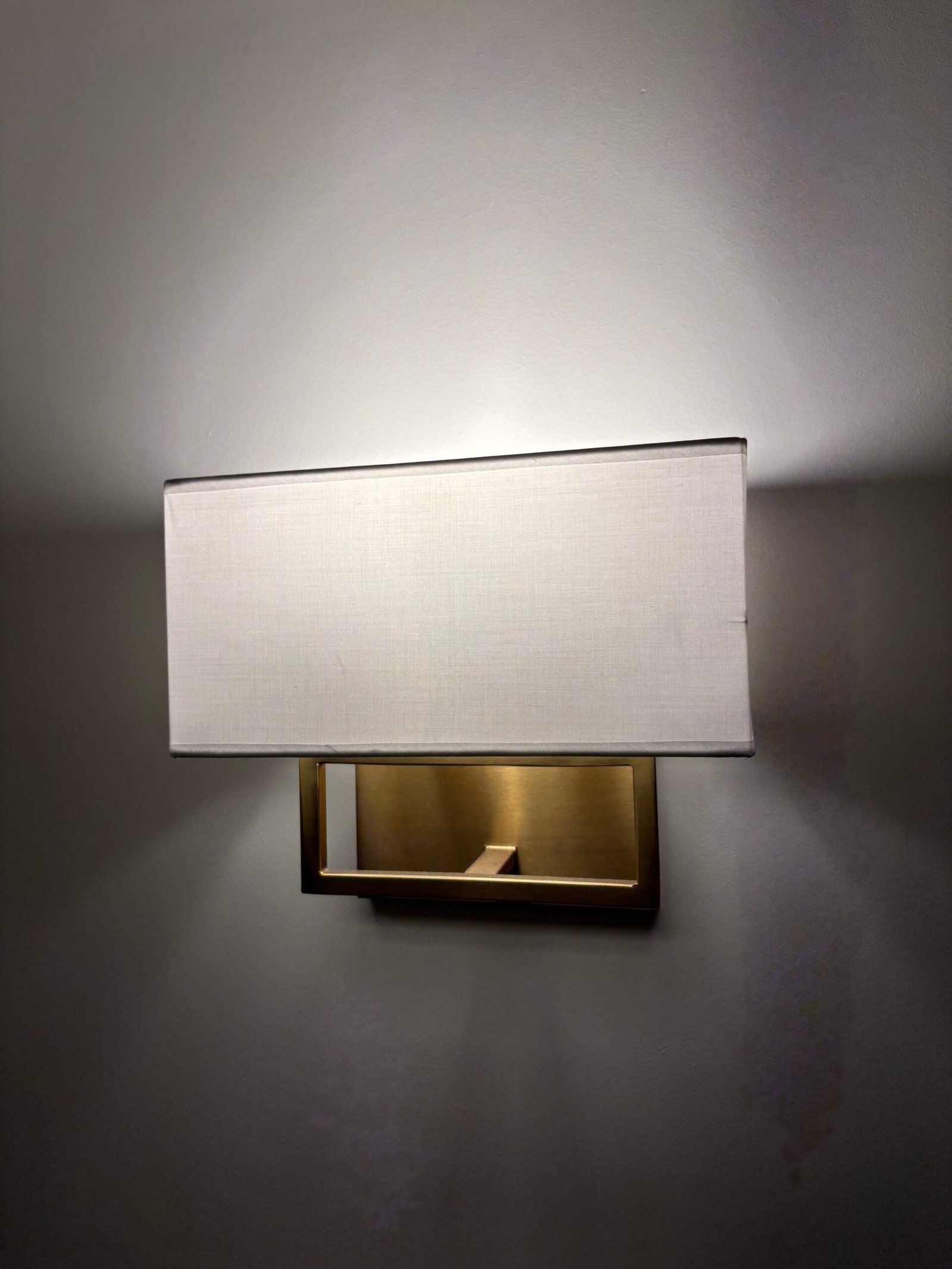 Brass wall sconce with linen shade installed, NYC