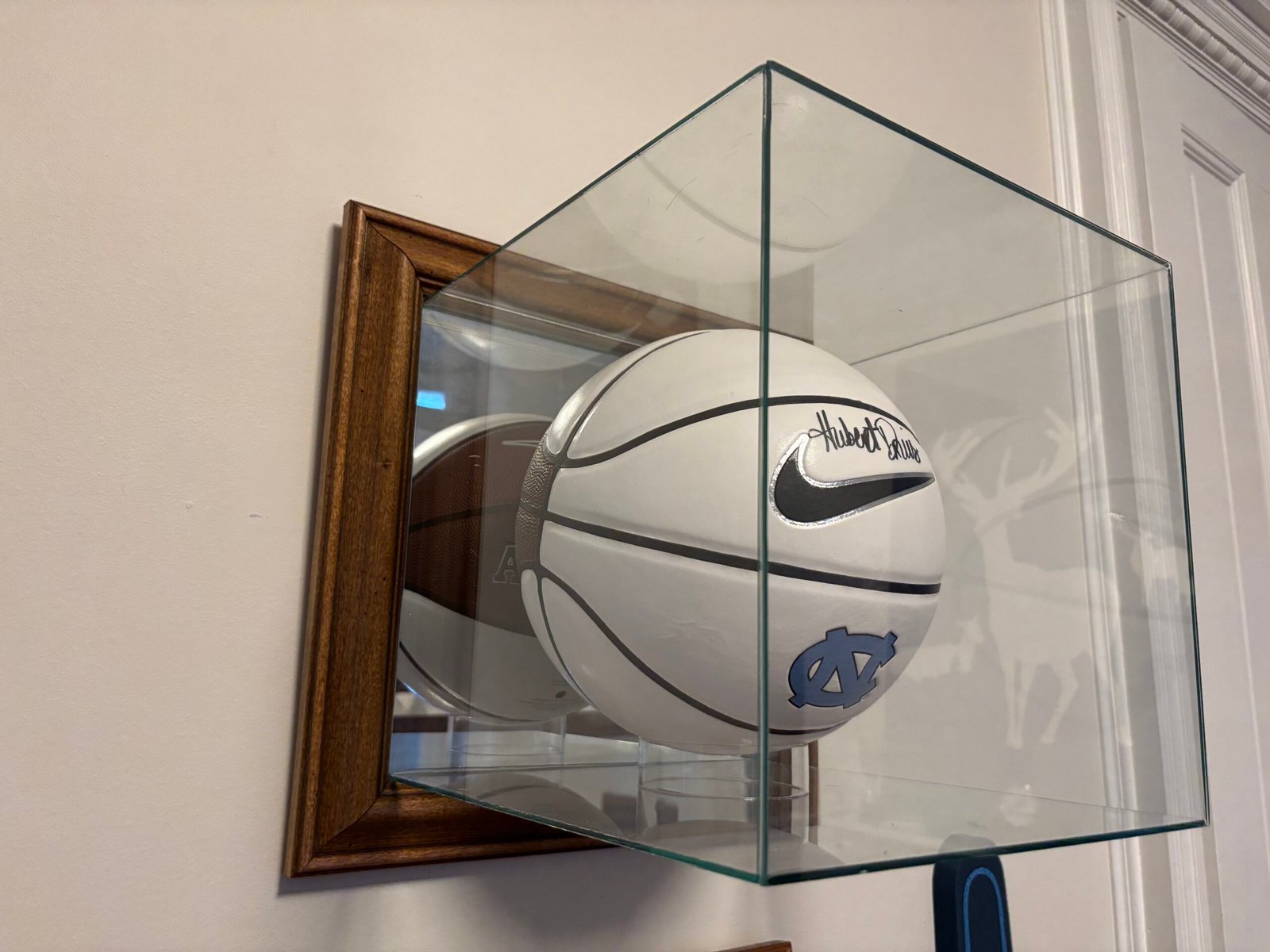 Signed basketball in a glass display case mounted on the wall, NYC