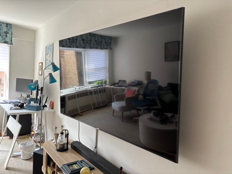 Large TV mounted on a wall in a living room with soundbar, NYC